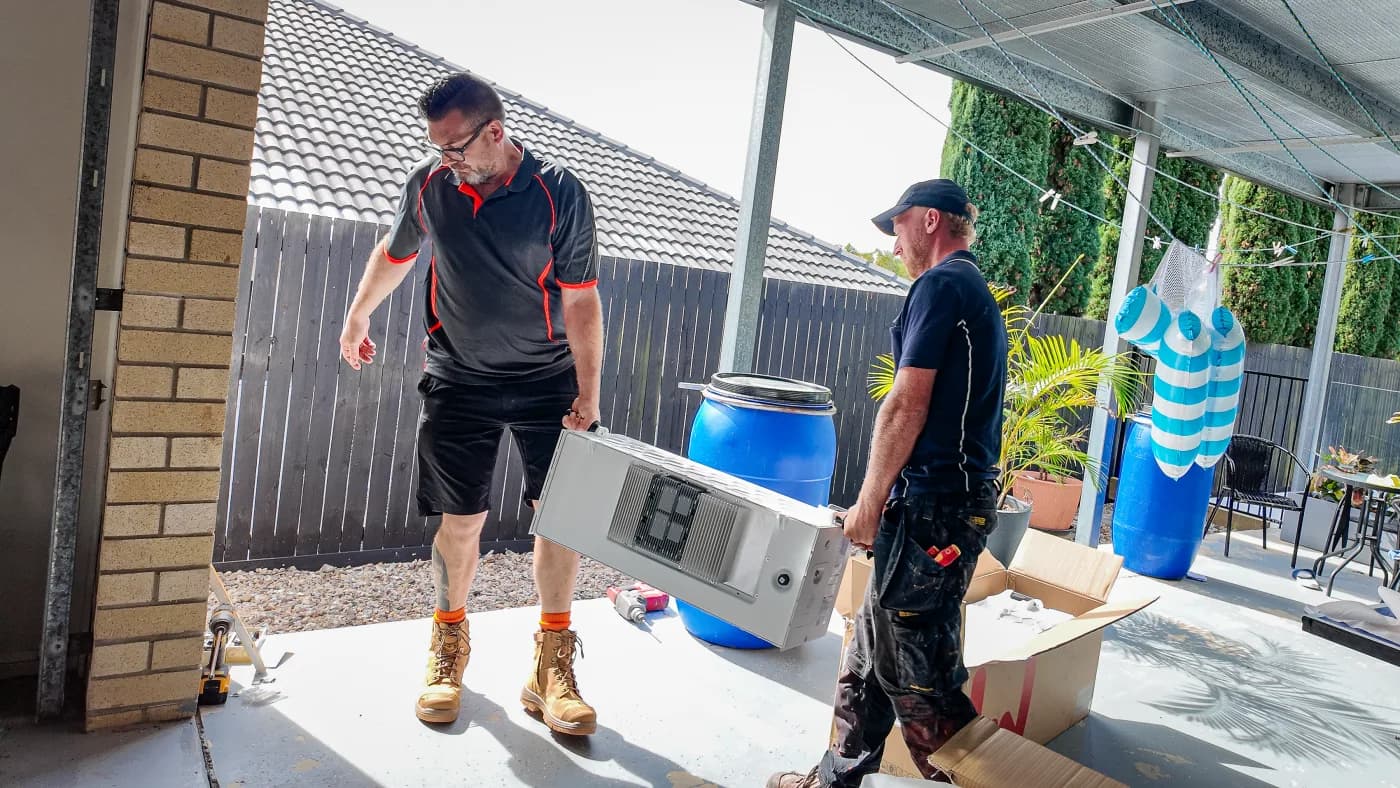 Worth Solar Group crew carrying a battery module across a job site
